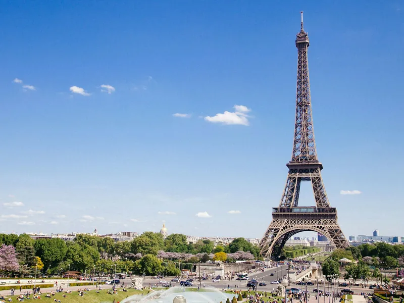 La tour Eiffel au-dessus des arbres sous un ciel bleu, à Paris