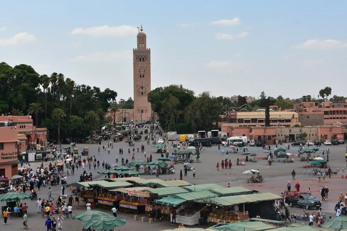 La place Jemaa el-Fna à Marrakech avec ses étals et le minaret de la Koutoubia en arrière-plan